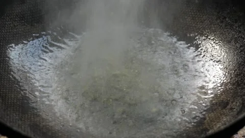A drop of water falls into a boiling pot of oil Stock Footage 314781347