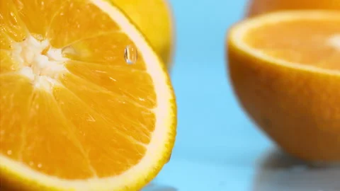 A drop of water falls on a slice of orange on the blue background at super slow  Stock Footage 338064502