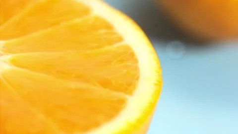 A drop of water falls on a slice of orange on the blue background at super slow  Stock Footage 338064650