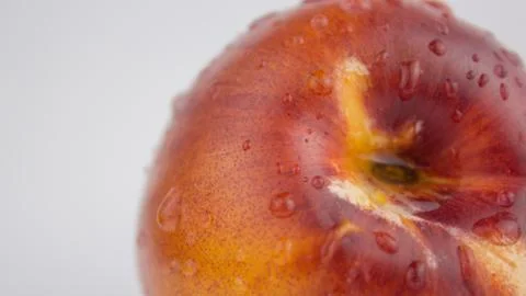 A drop of water flows down a fresh juicy peach. Fresh organic Peach covered w Stock Photos