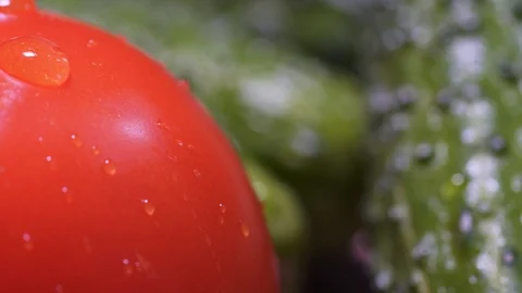 A drop of water flows down the red fresh tomato. A static macro shot. Green Видео 125771346
