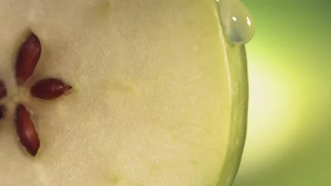 Drop of water flows down the surface of a ripe juicy Green Apple slice. Slow Video stock 199128667