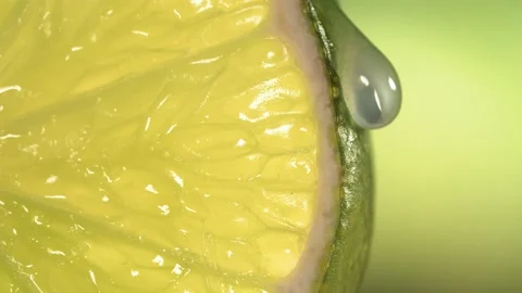 Drop of water flows down the surface of a ripe juicy Lime slice. Slow Motion 4K Stock Footage 199129632