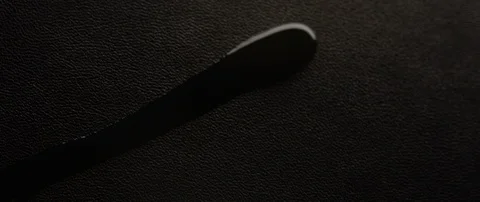 A drop of water flows over the black leather Stock Footage 106010797