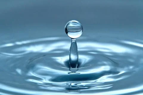 A drop of water hovering in the air before hitting a water surface, which wil Foto stock
