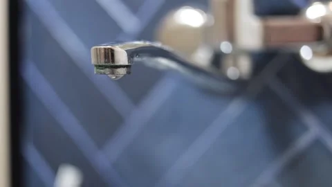 Drop of water slowly flows from tap, chrome faucet in hotel bath room Stock Footage 309964541
