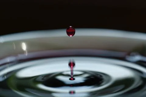 A drop in white Cup on black background Stock Photos