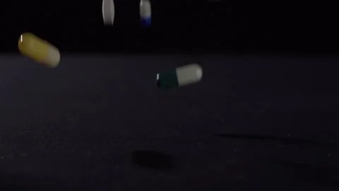 Droping pills slow motion Stock Footage 131851628