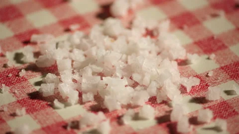 Droping Sea salt on a checkered kitchen table with red and white Видео 162624053