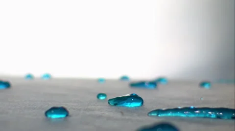 Droplets of blue liquid roll down incline like snails. Slow motion. ECU. Stock Footage 64884159
