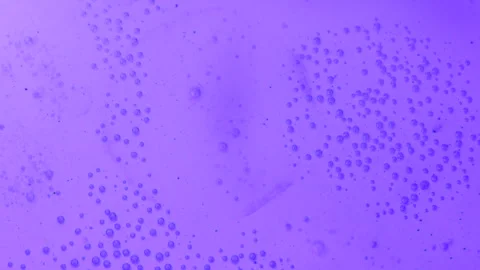 Droplets of bubbles in boiling water are filled with colored light Stock Footage 276321194