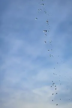Droplets cascade down a bright blue sky Stock Photos