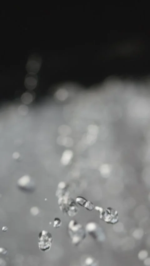 Droplets of clear water fall from rocks, each one highlighted in slow motio.. Vídeos de archivo 295032417
