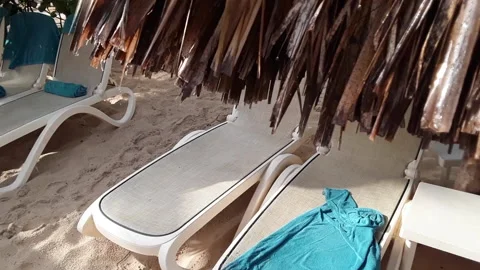 Droplets drip around edges of thatched beach umbrellas after Caribbean rainstorm Video stock 142830186