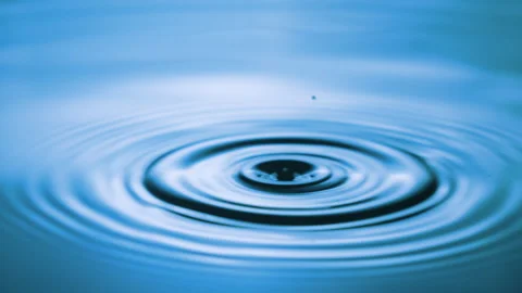 Droplets Fall Down on the Water Surface. Water Drop Making Ripples on Water Stock Footage 245688667