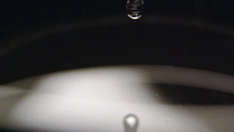 Droplets fall from thick pipette onto clean water macro Stock Footage 231720217