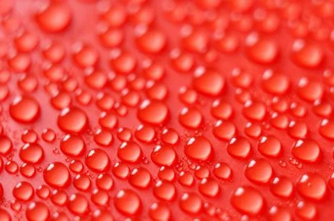 Droplets on red background Stock Photos