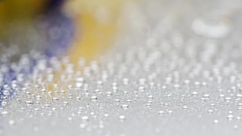 Droplets of water on a surface reflecting light in bright colors Stock Footage 332274408