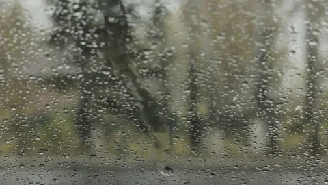 Droplets on a windshield on the day snow with rain. blured background Stock Footage