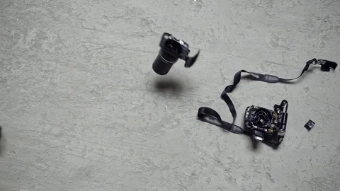 Dropped and shattered SLR camera in slow motion Stock Footage 80876818