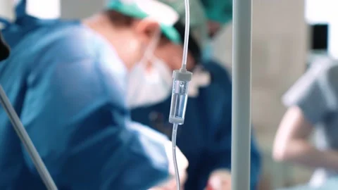 A dropper on the background of an operation in a hospital. Surgeons in the Stock Footage 228883994