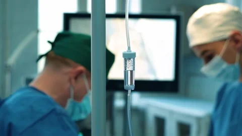 A dropper on the background of an operation in a hospital. Surgeons in the Stock Footage 228884029
