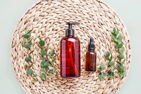 Dropper bottle, eucalyptus branches and dark dispenser bottle of shower gel o Stock-Fotos