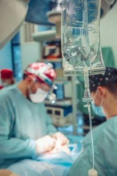 Dropper close-up on the background of the surgeon doing the operation Stock Photos