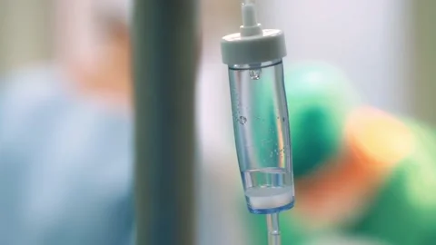 Dropper close-up, on the background Surgeons in the operating room perform an Stock Footage 221277015