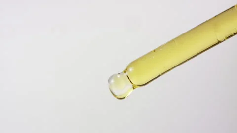Dropper with yellow green oil drop CBD medical chemistry refined extract Stock Footage 274454953