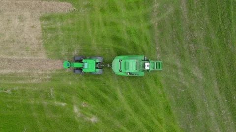 Dropping Aerial Drone view of tractor and baler Stock Footage 276962704
