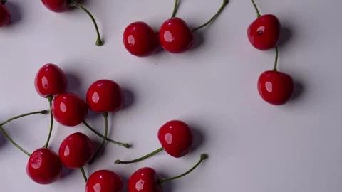 Dropping and picking up cherries on a white table Stock Footage 272724160