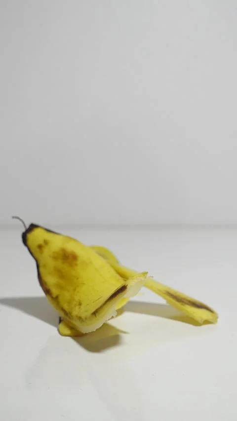 Dropping A Banana Peel Onto A White Table By Hand, First Person POV Stock Footage 346412859