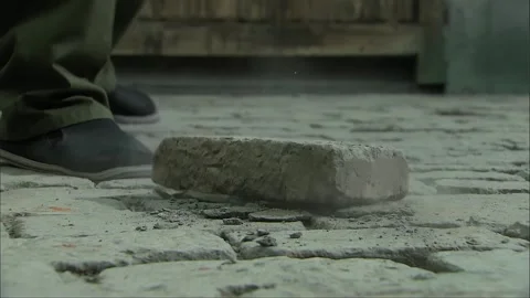 Dropping the brick in hand, turning around, and walking away Stock Footage 276451117