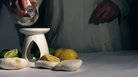 Dropping Citrus Essential oils into aromatherapy oil burner Stock Footage 270085698