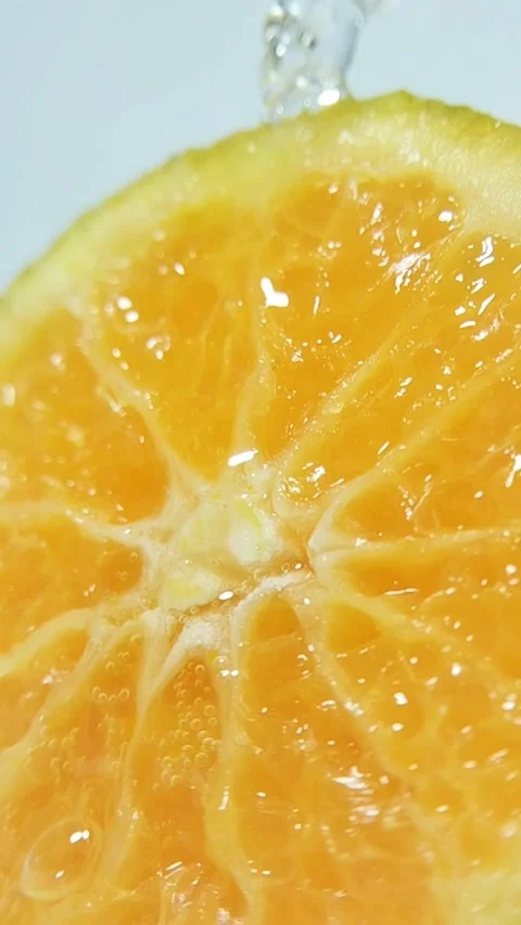 Dropping clear liquid onto a fresh orange slice. Liquid absorbs into citrus.. Stock Footage 330749477