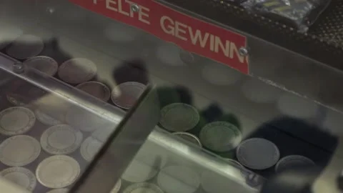 Dropping Coin Into A Coin Dozer Machine With Pushing The Other Coins Afterwards Stock Footage 130676696