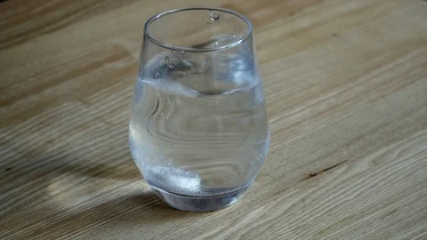 Dropping a effervescent tablet in a glass of water and making bubbles. Stock Footage 125078392
