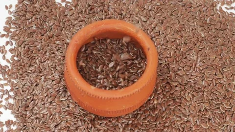 Dropping flax seeds over mud glass, Close view of dropping flax seeds Video stock 147851460