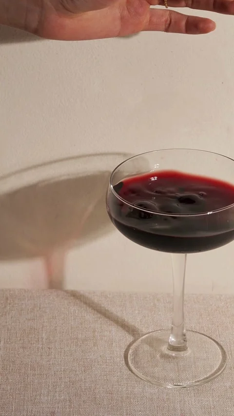 Dropping fresh red cherries into a glass of wine Video stock 331773562