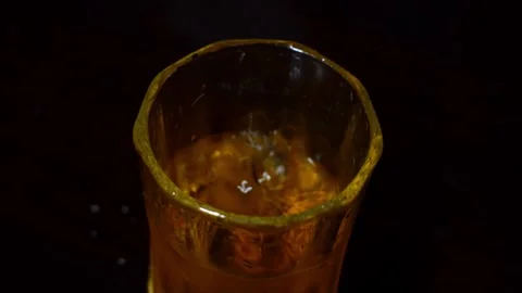 Dropping Ice Cube into a Glass of Amber Soft Drink 库存影片 347529981