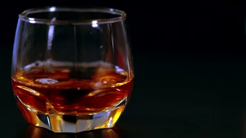 Dropping ice cubes into a tot of whiskey Video stock 115081352
