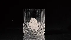 Ice cube falling into whisky glass – License Images – 11039807