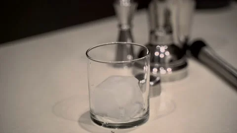 Dropping large ice cube into rocks glass in slow motion Stock Footage 221588133