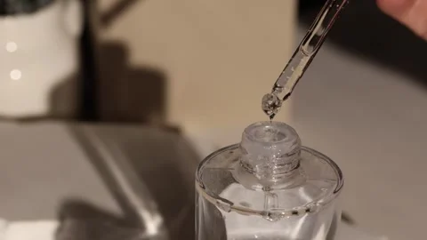 Dropping liquid into a clear bottle Stock Footage 336675265