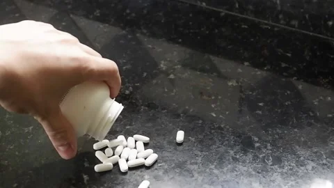 Dropping medicine pills on the table Stock Footage 141855018