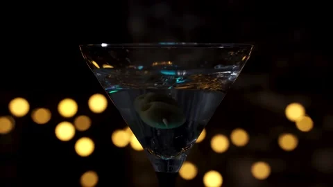 Dropping olives on toothpick and slice of lemon into martini glass filled Video stock 130321259