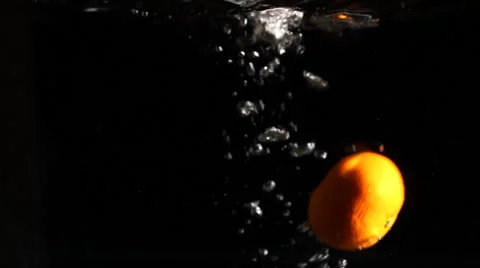 Dropping an orange in water Stock Footage 46724117