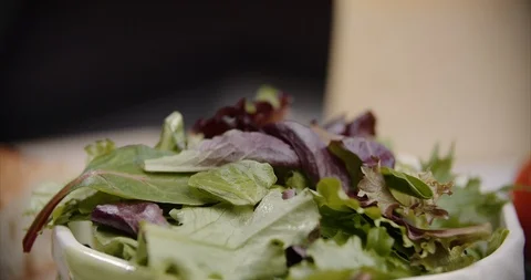 Dropping pecans onto a fresh mixed salad Stock Footage 101174656