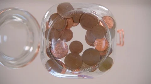 Dropping Pennies into Jar Stock Footage 123796176